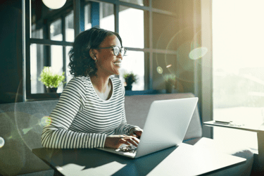 Dunkelhäutige Frau arbeitet im Büro am Laptop